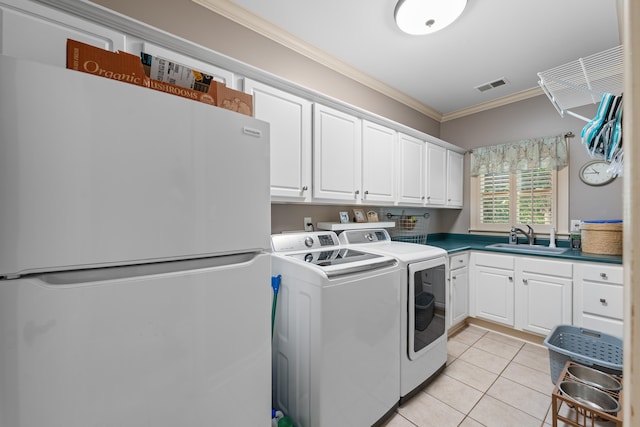 9245 Forest Estates Cv, Germantown, TN 38139 - washroom featuring washing machine and dryer, ornamental molding, cabinet space, and light tile patterned flooring