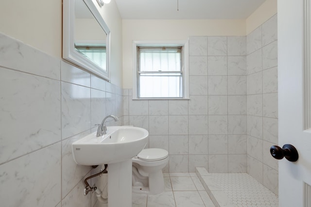 5151 Canton Dr, Memphis, TN 38116 - bathroom featuring tile walls, toilet, tiled shower, and a wainscoted wall