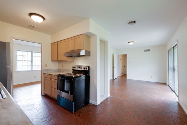 5151 Canton Dr, Memphis, TN 38116 - kitchen with black electric range oven, under cabinet range hood, freestanding refrigerator, baseboards, and light countertops