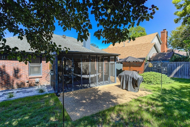 3120 Caledonia Rd, Memphis, TN 38119 - back of house featuring a sunroom, brick siding, roof with shingles, a patio area, and a chimney