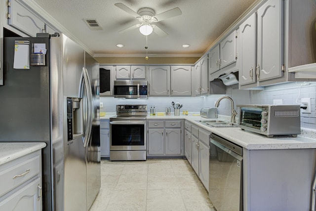 3120 Caledonia Rd, Memphis, TN 38119 - kitchen featuring appliances with stainless steel finishes, a sink, a ceiling fan, gray cabinets, and ornamental molding