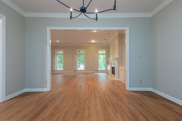 1060 Island Dr, Memphis, TN 38103 - unfurnished dining area with ornamental molding, light wood-style floors, a chandelier, baseboards, and a fireplace with flush hearth