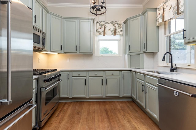 1060 Island Dr, Memphis, TN 38103 - kitchen with high quality appliances, a sink, gray cabinetry, wood finished floors, and ornamental molding