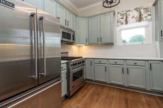 1060 Island Dr, Memphis, TN 38103 - kitchen with high quality appliances, gray cabinetry, ornamental molding, dark wood finished floors, and light countertops
