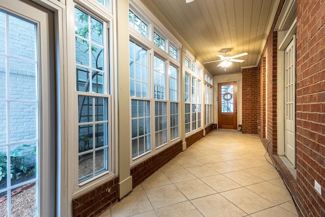 1060 Island Dr, Memphis, TN 38103 - unfurnished sunroom with brick wall, a ceiling fan, tile patterned flooring, and wood ceiling