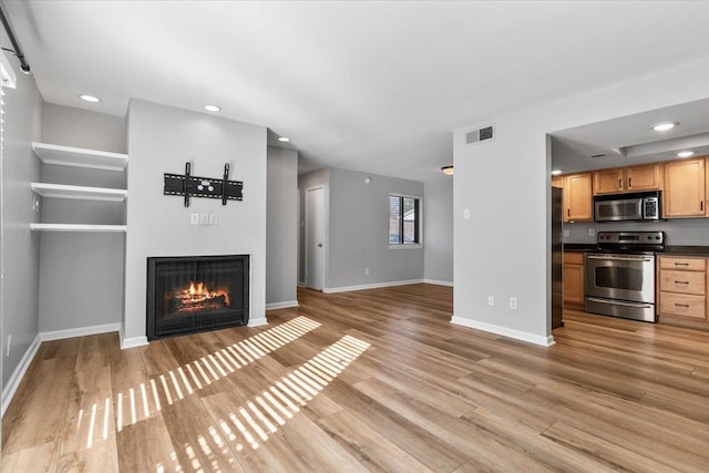 1829 Eagle Branch Cv Unit 41, Germantown, TN 38138 - unfurnished living room with a warm lit fireplace, light wood-type flooring, recessed lighting, and baseboards