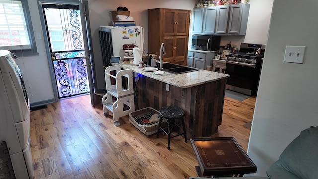 2304 Longstreet Dr, Memphis, TN 38114 - kitchen with appliances with stainless steel finishes, a sink, light wood finished floors, and light stone counters