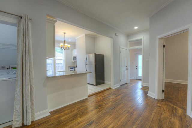 1224 Faxon Ave, Memphis, TN 38104 - kitchen featuring appliances with stainless steel finishes, washer / dryer, wood finished floors, a chandelier, and ornamental molding
