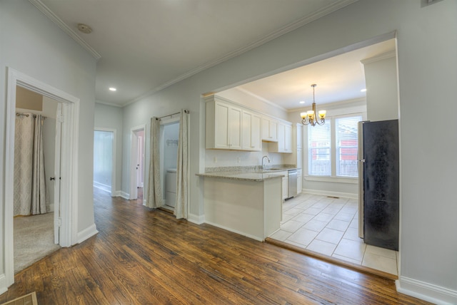 1224 Faxon Ave, Memphis, TN 38104 - kitchen featuring appliances with stainless steel finishes, a sink, wood-type flooring, a chandelier, and white cabinets