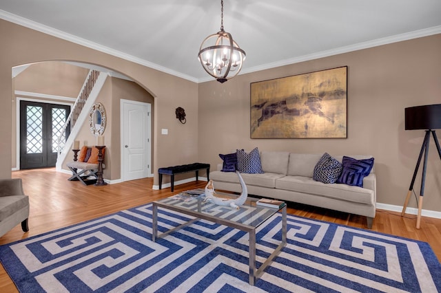 546 Township Cv, Collierville, TN 38017 - living area with arched walkways, a chandelier, wood finished floors, crown molding, and baseboards