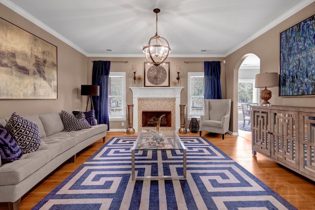 546 Township Cv, Collierville, TN 38017 - living area featuring arched walkways, wood finished floors, a chandelier, ornamental molding, and a fireplace