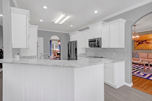546 Township Cv, Collierville, TN 38017 - kitchen with arched walkways, appliances with stainless steel finishes, decorative backsplash, recessed lighting, and white cabinets