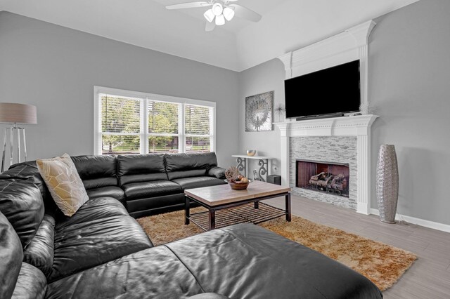 546 Township Cv, Collierville, TN 38017 - living room featuring wood finished floors, a ceiling fan, a tiled fireplace, and baseboards
