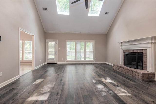 1625 Autumn Tree Cv, Memphis, TN 38016 - unfurnished living room with high vaulted ceiling, ceiling fan, a skylight, wood finished floors, and a brick fireplace