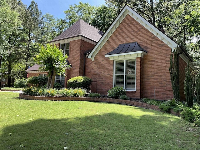 1625 Autumn Tree Cv, Memphis, TN 38016 - view of home's exterior with a standing seam roof, brick siding, a yard, and metal roof