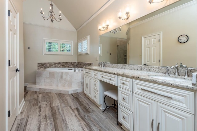 1625 Autumn Tree Cv, Memphis, TN 38016 - bathroom featuring double vanity, lofted ceiling, a garden tub, ornamental molding, and a chandelier
