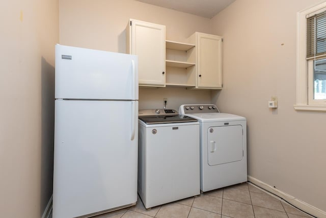 1625 Autumn Tree Cv, Memphis, TN 38016 - laundry area featuring washer and dryer, cabinet space, light tile patterned floors, and baseboards