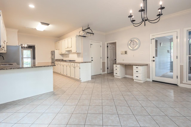 1625 Autumn Tree Cv, Memphis, TN 38016 - kitchen featuring a chandelier, ornamental molding, dark stone counters, freestanding refrigerator, and a sink