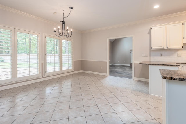 1625 Autumn Tree Cv, Memphis, TN 38016 - unfurnished dining area with a chandelier, light tile patterned flooring, crown molding, and baseboards