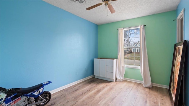 6861 Sauterne Cv, Memphis, TN 38115 - spare room featuring a textured ceiling, light wood-style floors, a ceiling fan, and baseboards