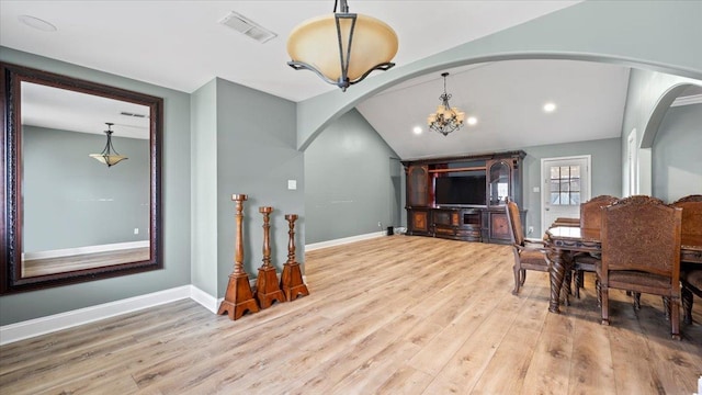 6861 Sauterne Cv, Memphis, TN 38115 - dining area with arched walkways, wood finished floors, lofted ceiling, baseboards, and a chandelier