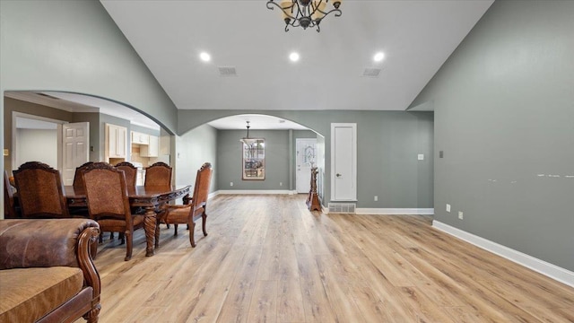 6861 Sauterne Cv, Memphis, TN 38115 - dining space with arched walkways, a chandelier, high vaulted ceiling, baseboards, and light wood-style flooring