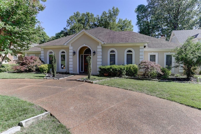 6703 N Kirby Oaks Cv, Memphis, TN 38119 - view of front facade featuring stucco siding, a front lawn, and a shingled roof