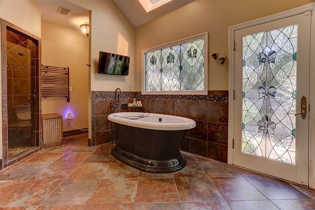 6703 N Kirby Oaks Cv, Memphis, TN 38119 - bathroom featuring tile walls, a freestanding bath, plenty of natural light, a stall shower, and wainscoting