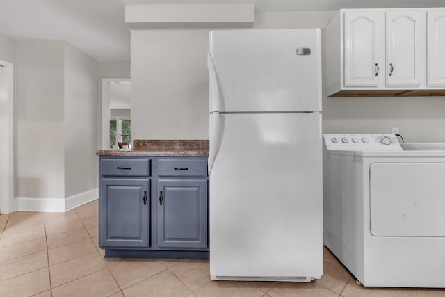 5251 Sequoia Ave, Memphis, TN 38120 - kitchen with freestanding refrigerator, washer / dryer, white cabinetry, light tile patterned floors, and baseboards