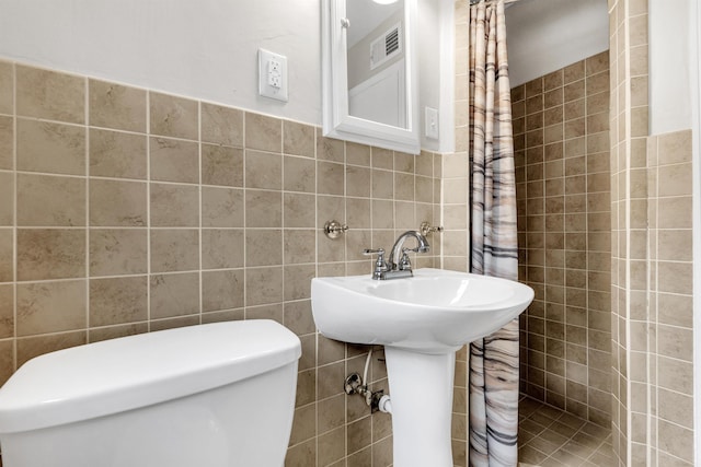 5251 Sequoia Ave, Memphis, TN 38120 - bathroom featuring tile walls, toilet, and a sink