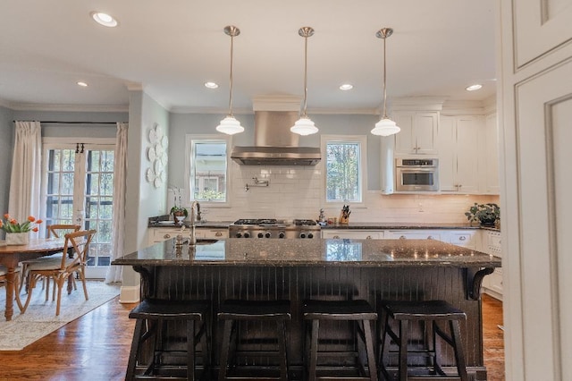 1514 Vance Ave, Memphis, TN 38104 - kitchen with wall chimney range hood, crown molding, a sink, healthy amount of natural light, and a breakfast bar