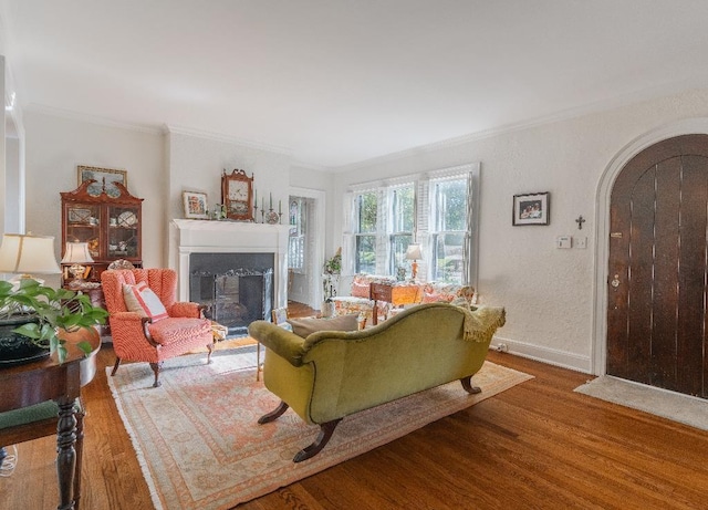 1514 Vance Ave, Memphis, TN 38104 - living area with wood finished floors, arched walkways, a fireplace with flush hearth, crown molding, and baseboards