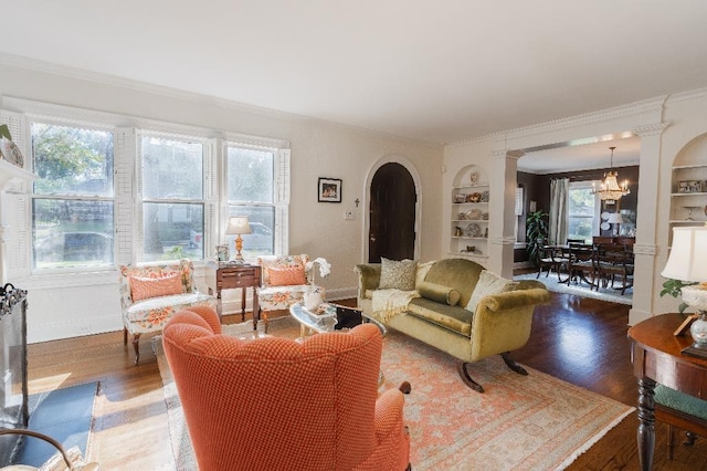 1514 Vance Ave, Memphis, TN 38104 - living room with arched walkways, crown molding, built in features, light wood-style floors, and a chandelier