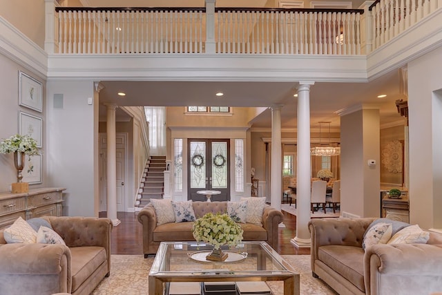 9470 Riveredge Dr, Memphis, TN 38018 - living room with decorative columns, a high ceiling, light wood finished floors, crown molding, and stairway