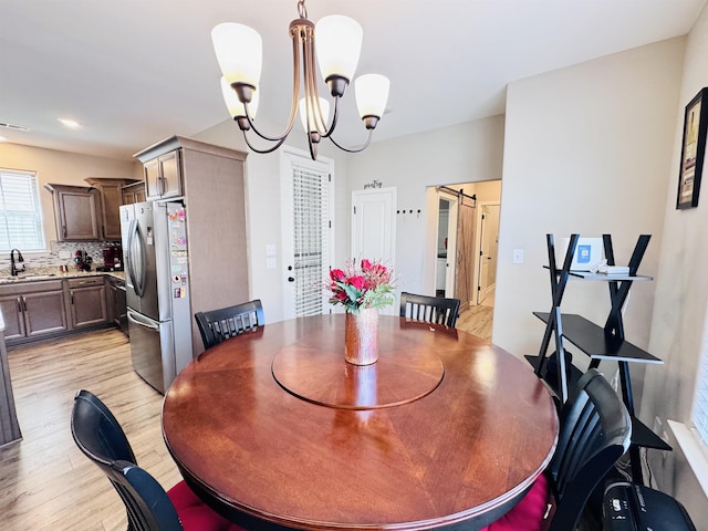 10156 Amberton Cv, Cordova, TN 38018 - dining room featuring light wood-type flooring, a chandelier, and a barn door