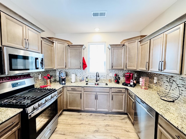 10156 Amberton Cv, Cordova, TN 38018 - kitchen with stainless steel appliances, a sink, light wood-style flooring, and backsplash