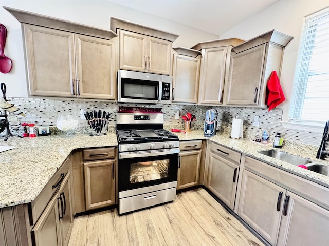 10156 Amberton Cv, Cordova, TN 38018 - kitchen with appliances with stainless steel finishes, light wood-style flooring, decorative backsplash, a sink, and plenty of natural light