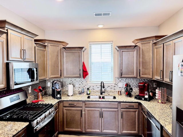 10156 Amberton Cv, Cordova, TN 38018 - kitchen with stainless steel appliances, a sink, tasteful backsplash, and light stone counters