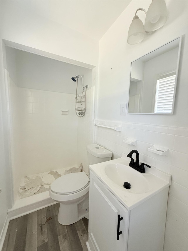 1170 Stage Ave, Memphis, TN 38127 - bathroom featuring a stall shower, wood finished floors, vanity, toilet, and tile walls