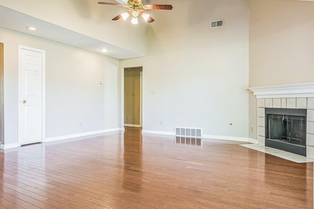 1168 E Red Fern Cir, Cordova, TN 38018 - unfurnished living room featuring a ceiling fan, a towering ceiling, light wood finished floors, baseboards, and a tile fireplace