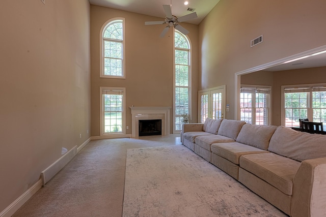 10223 Poston Oaks Cir, Collierville, TN 38017 - carpeted living room featuring a towering ceiling, healthy amount of natural light, baseboards, a ceiling fan, and a fireplace