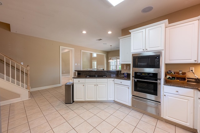 10223 Poston Oaks Cir, Collierville, TN 38017 - kitchen with oven, a warming drawer, built in microwave, black stovetop, and a peninsula