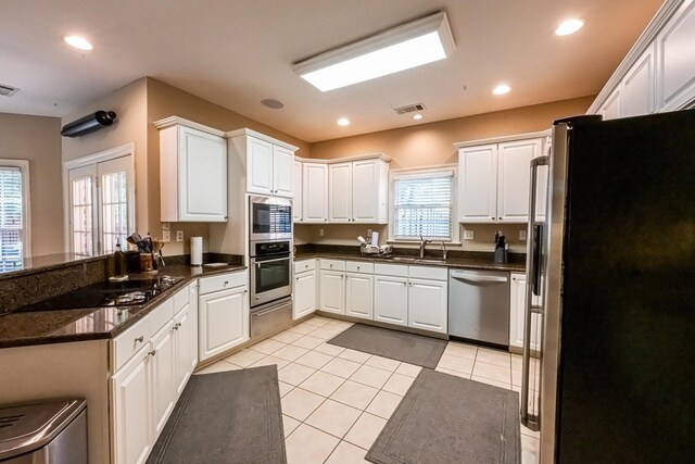 10223 Poston Oaks Cir, Collierville, TN 38017 - kitchen featuring appliances with stainless steel finishes, light tile patterned floors, white cabinets, a sink, and recessed lighting