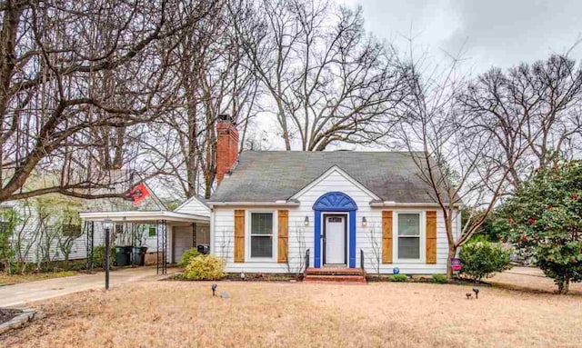 18 N Reese St, Memphis, TN 38111 - view of front of house featuring a carport, concrete driveway, a chimney, and a front lawn