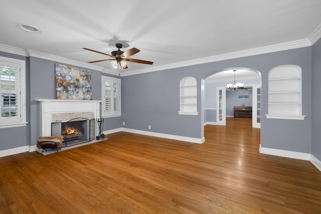 18 N Reese St, Memphis, TN 38111 - unfurnished living room with a chandelier, a fireplace, built in features, arched walkways, and wood finished floors