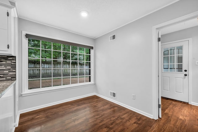 2349 Riverdale Rd, Germantown, TN 38138 - unfurnished dining area featuring dark wood-style flooring, crown molding, and baseboards