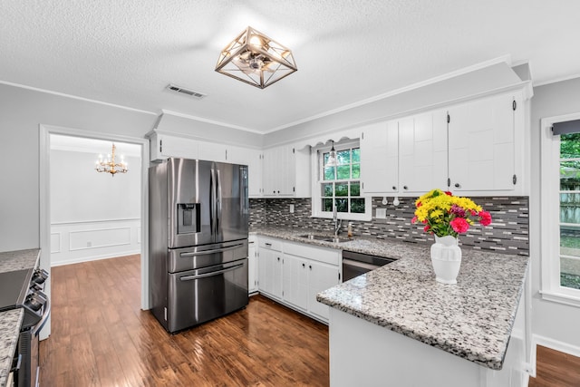2349 Riverdale Rd, Germantown, TN 38138 - kitchen with appliances with stainless steel finishes, a chandelier, crown molding, a peninsula, and tasteful backsplash