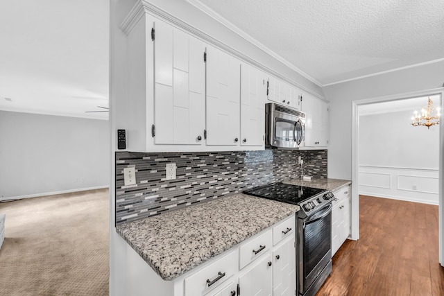 2349 Riverdale Rd, Germantown, TN 38138 - kitchen with stainless steel appliances, backsplash, white cabinetry, crown molding, and a chandelier