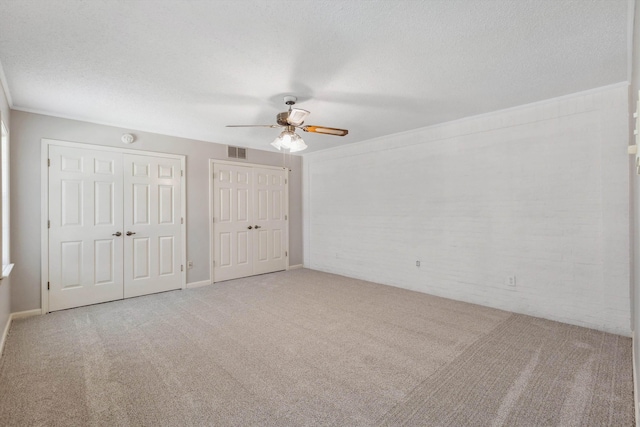 7617 Hollow Fork Rd, Germantown, TN 38138 - unfurnished bedroom with multiple closets, carpet floors, a textured ceiling, and ceiling fan
