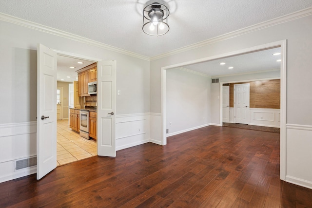 7617 Hollow Fork Rd, Germantown, TN 38138 - empty room with hardwood / wood-style flooring, wainscoting, crown molding, a textured ceiling, and a decorative wall